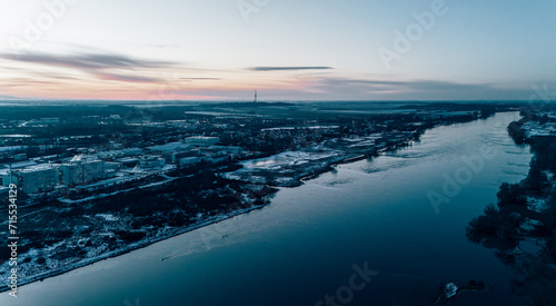 Aerial View of a City during sunset reflecting in a calm river