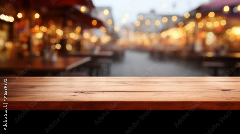 Empty wooden surface with a backdrop of a bustling street market illuminated by warm, blurry lights at twilight.