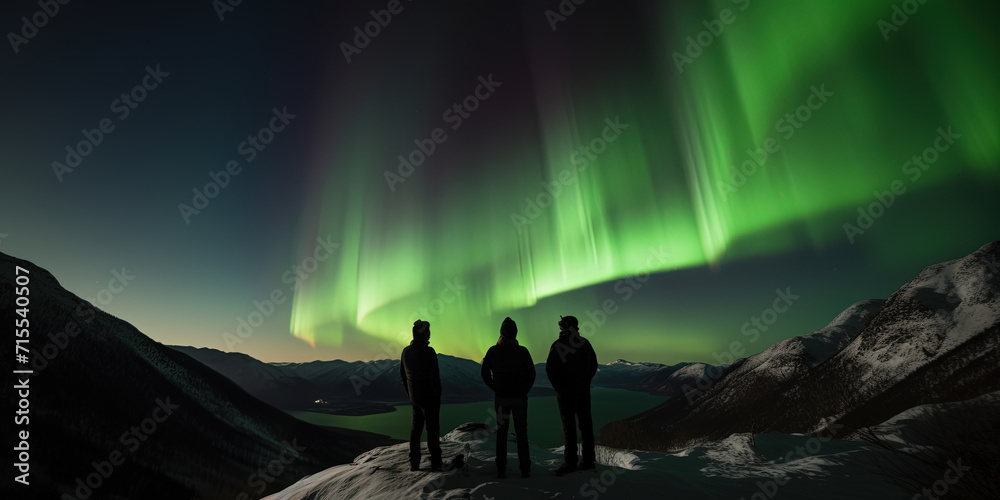 silhouettes of three men who observe an aurora a natural phenomenon of Northern Lights