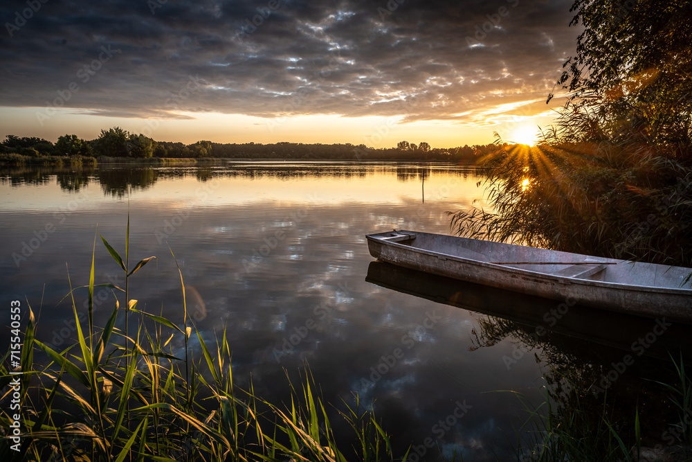 cudowny wschód słońca nad jeziorem i łódka przy brzegu - obrazy, fototapety, plakaty 