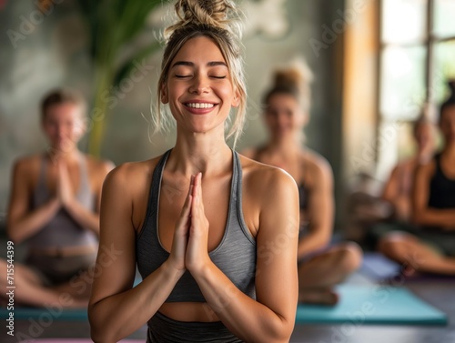 A smiling woman taking a yoga group class