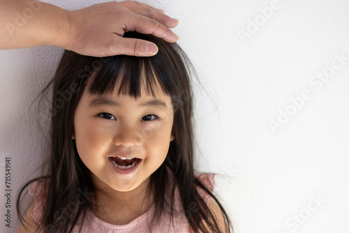 頭を撫でられて笑顔の女の子（3歳、日本人）