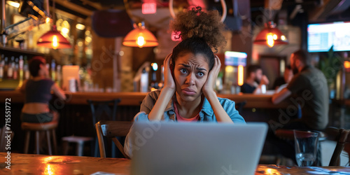 Frustrated Woman Struggles With Laptop Issues While In A Bustling Bar. Сoncept Frustrated Woman, Laptop Issues, Bustling Bar, Multitasking, Technology Struggles