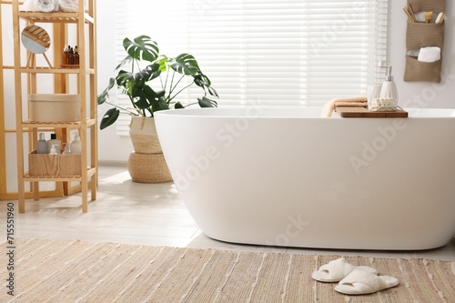 Set of different bath accessories and soap on tub in bathroom photo