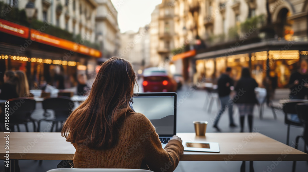 Young freelancer woman using laptop computer sitting at cafe table. Happy Smiling Girl Working Online Or Studying And Learning While Using Notebook. Young freelancer woman using laptop computer sitting at cafe table. Happy Smiling Girl Working Online Or Studying And Learning While Using Notebook.