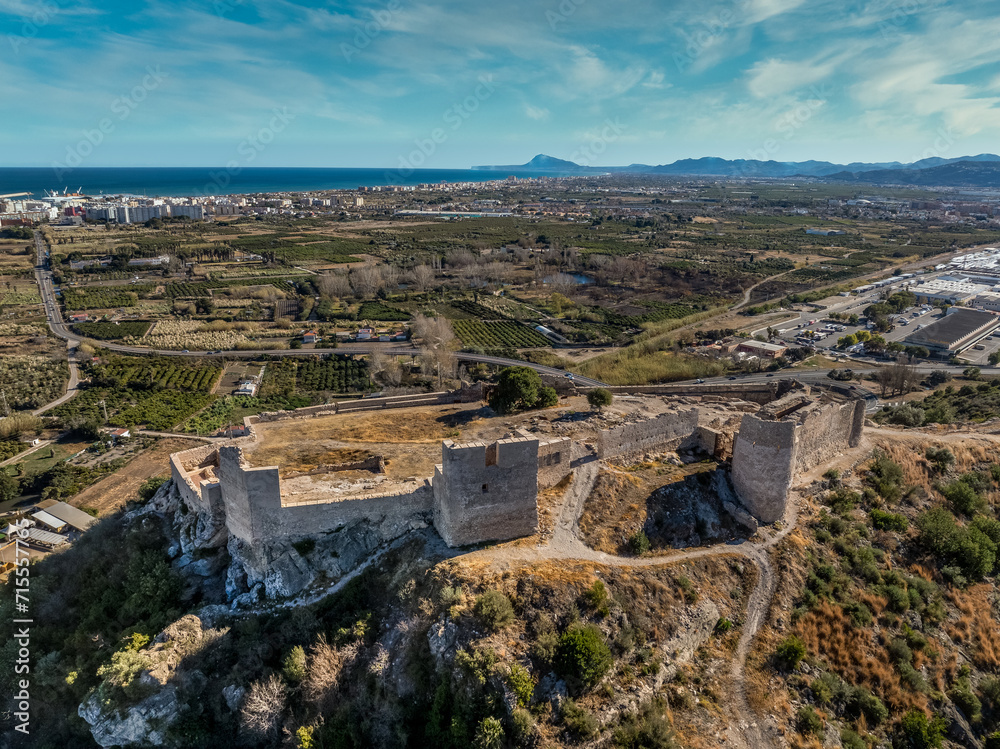 Aerial view of Bairen medieval castle ruin near Gandia in Spain with partially restored circular towers with cloudy sky