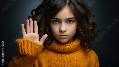 Portrait of kid doing stop sing with palm of hand. Warning expression with negative and serious gesture on face. People emotion lifestyle concept photo