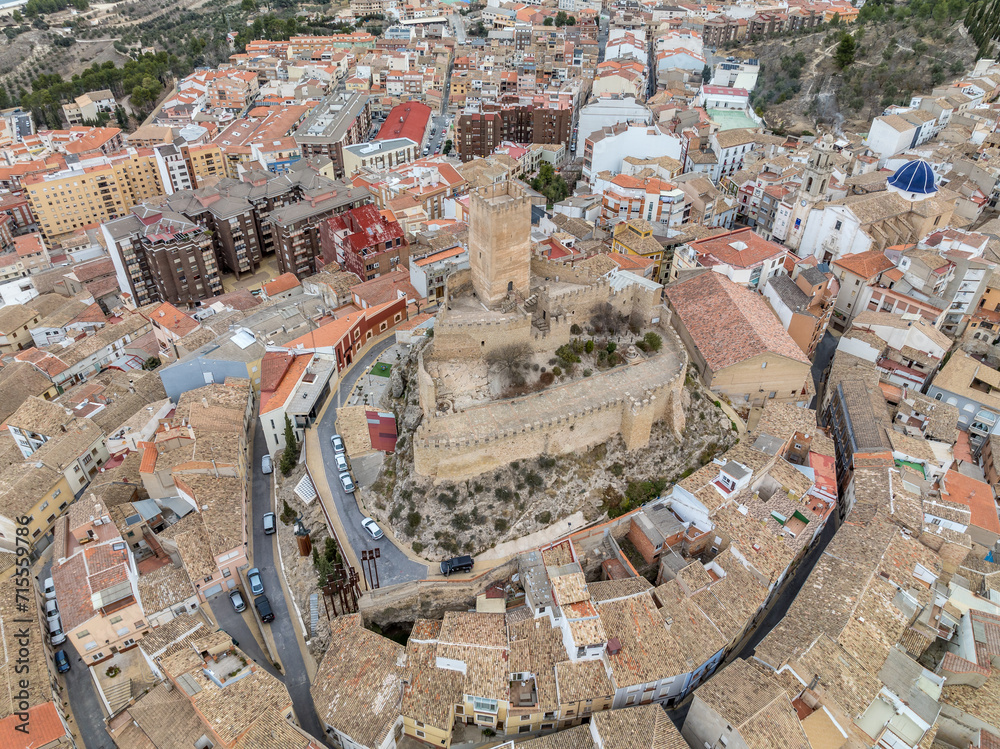 Aerial view of Banyeres de mariola medieval castle, large square tower surrounded by courtyard with round towers in Spain
