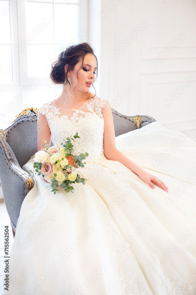 Beautiful brunette woman with bouquet posing in a wedding dress Beautiful brunette woman with bouquet posing in a wedding dress