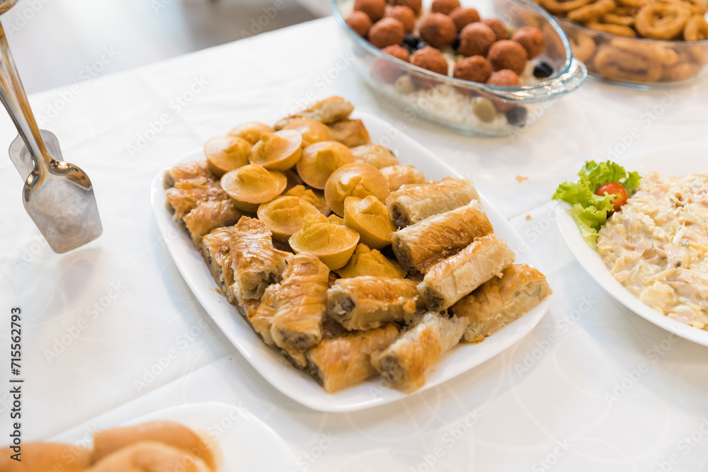 assortment of delicious appetizers, expertly arranged on a captivating catering table assortment of delicious appetizers, expertly arranged on a captivating catering table