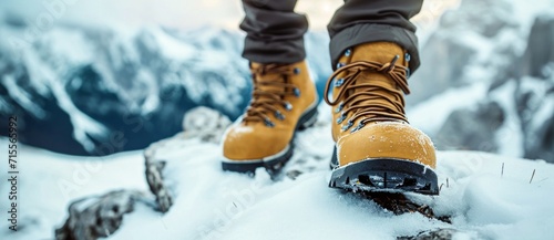 Trudging through the snowy mountains, a person's feet are snugly encased in sturdy snow boots, braving the freezing temperatures for an adventurous winter hike