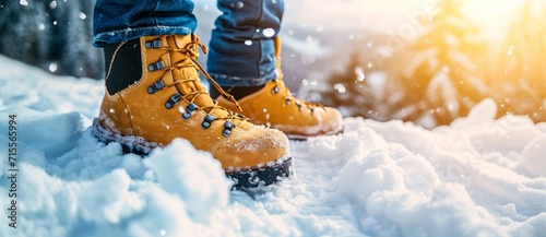 A person's feet stay warm and stylish in their yellow snow boots while braving the winter wonderland outdoors photo