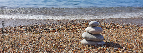 Spa stones balance on the sand of the beach.