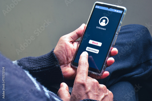 Obraz na plátně Man blocking unknown caller phone number to prevent voice phishing scam