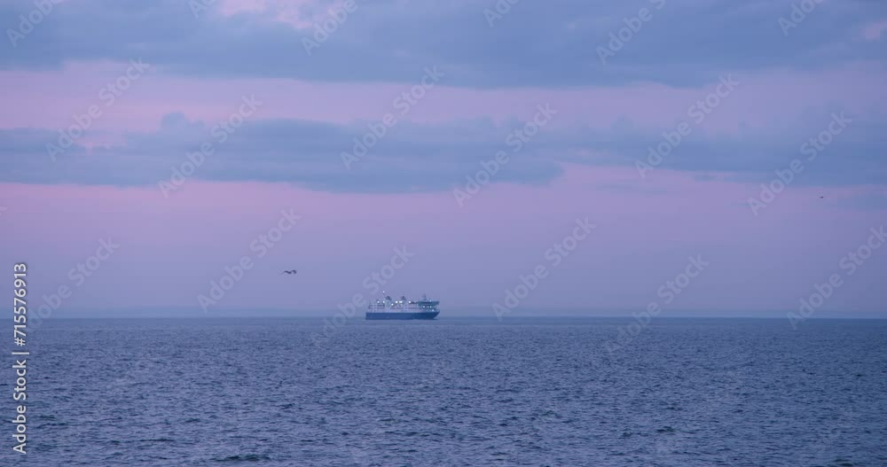 Ferry boat water on distance in atmospheric purple vanilla sky sunset with clouds in sky Ferry boat water on distance in atmospheric purple vanilla sky sunset with clouds in sky