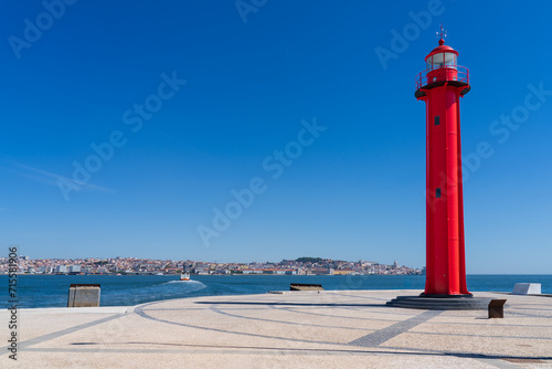 Farol de Cacilhas, Red lighthouse in the port of Almada, located on the southern margin of the Tagus River, on the opposite side of the river from Lisbon, Portugal photo