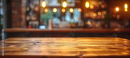 Empty wooden table set in bar or pub counter defining interior of cafe light casting blurred shadows in restaurant drink ambiance at night top view against dark background desk space