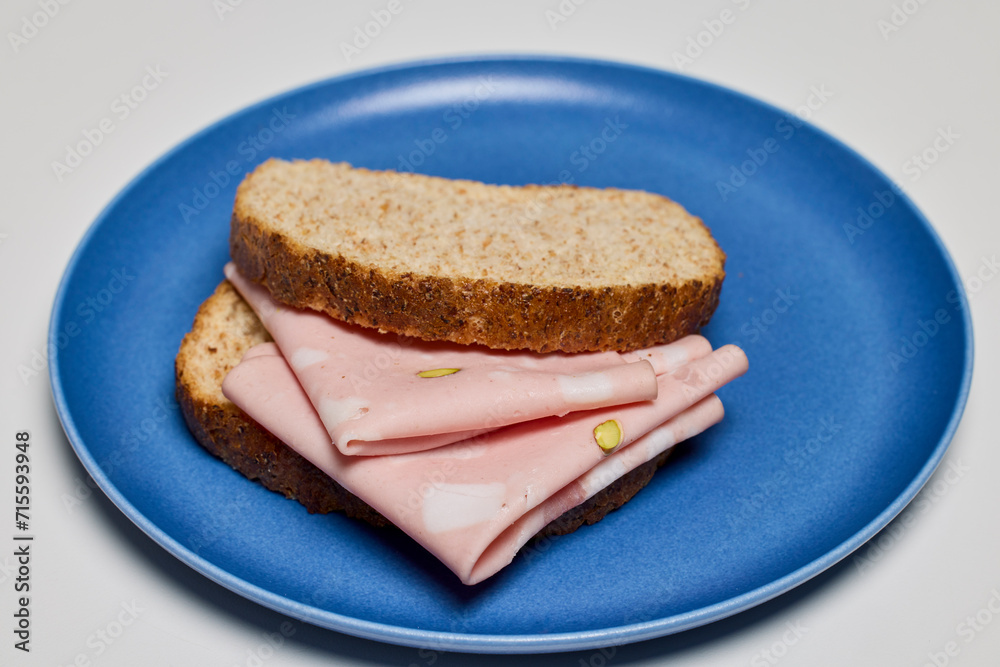 slices of bread with mortadella on a plate.