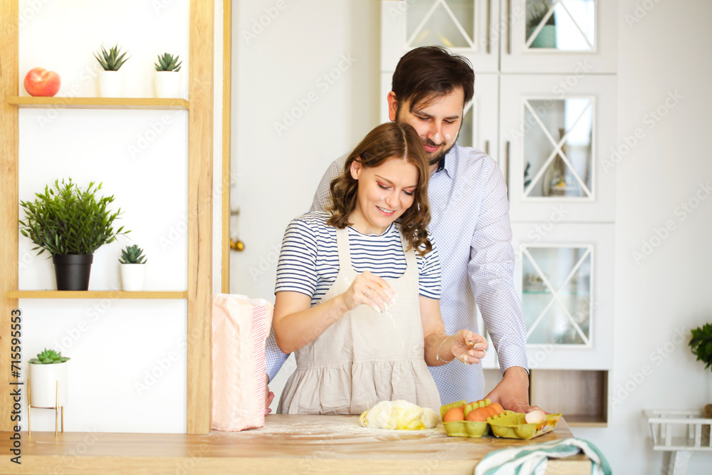 Happy couple cooking and embracing in kitchen