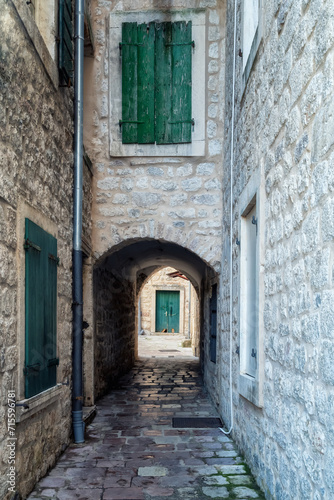 Morning walk along winding narrow streets with ancient stone buildings in the old town of Kotor, Montenegro