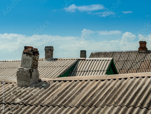 roofs and chimneys of old houses against the blue sky and white © Sofiia