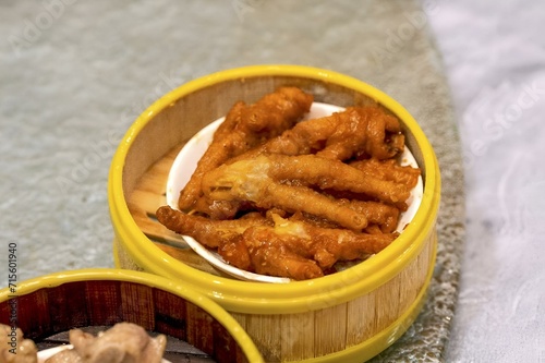 a small wooden bowl with hot wings on top of a plate