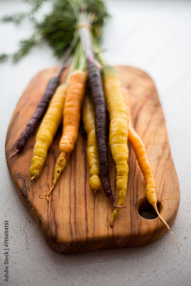 rainbow carrots on a wooden chopping board rainbow carrots on a wooden chopping board