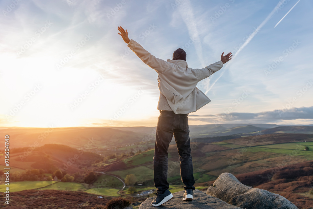 happy handsome man tourist with backpack hiking and enjoying mountains landscape at sunset in England. A trip to the mountains with a backpack. Enjoy hiking and exploring new places concept happy handsome man tourist with backpack hiking and enjoying mountains landscape at sunset in England. A trip to the mountains with a backpack. Enjoy hiking and exploring new places concept