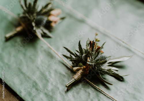 Foto Close up of two wedding buttinhole thistles pinned to a green board