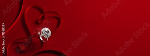 A white gold engagement ring with diamonds and a heart-shaped ribbon on a red background. Romantic wedding jewelry background.