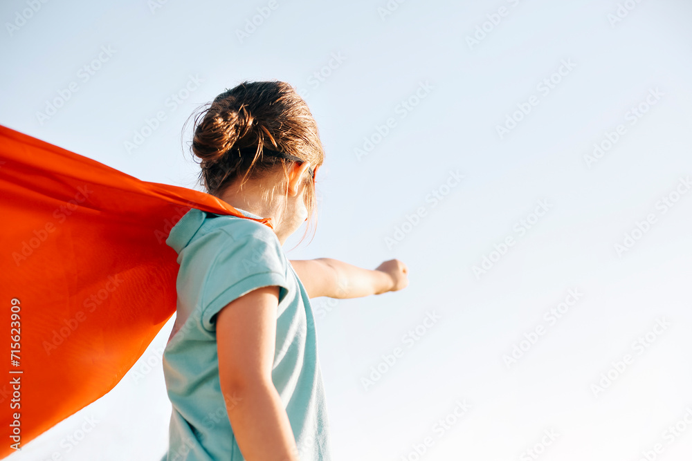 Superhero kid against blue sky background