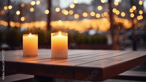 Lit up candle at an outdoor table of a restaurant in winter, cosy atmosphere, selective focus, bokeh.