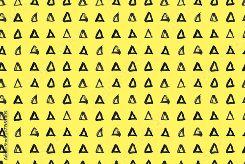 Dash pattern on yellow background. Wrapping paper with small black triangles painted with a brush. Seamless simple minimal ornament. Abstract geometric grunge vector texture painted by ink.