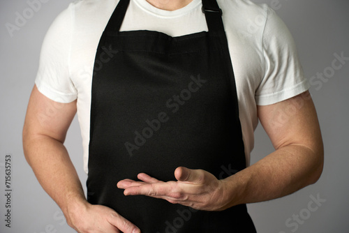 Male chef wearing apron and pointing with hand