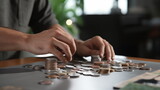 Save money : Man counting coins on table. AI Generative.