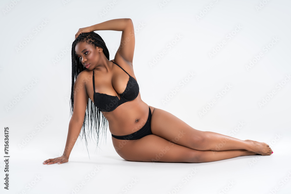 Curvy busty plus size model in underwear on gray background, overweight African black woman in sexy lingerie, fat body