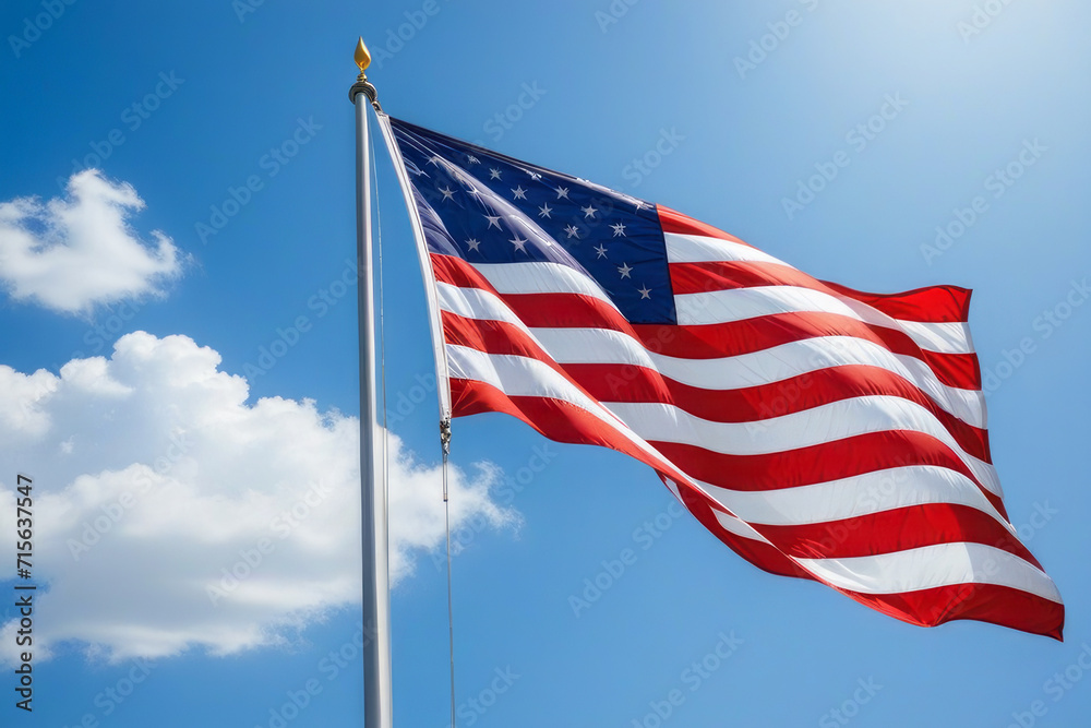 Fototapeta premium American flag develops against a blue sky. A symbol of country and freedom.