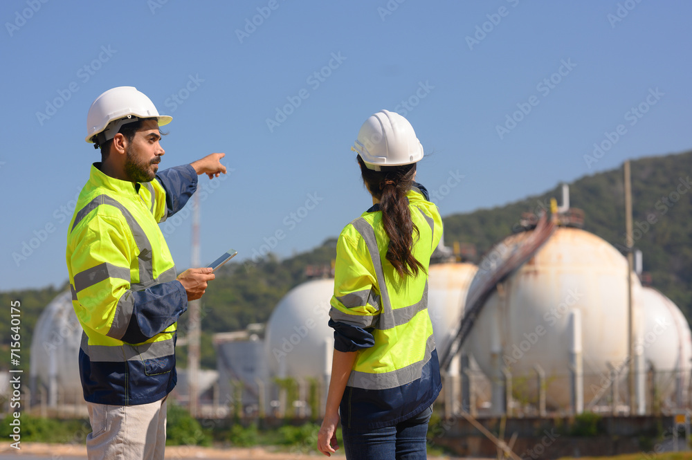 Two chemical engineers consult to prepare a work plan for a refinery storage tank.
Two chemical engineers consult to prepare a work plan for a refinery storage tank.