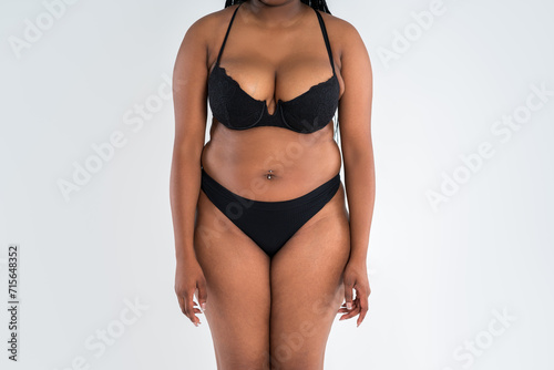 Curvy busty plus size model in push up bra on gray background, overweight African black woman in sexy lingerie, fat body