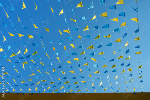 Colorful flags on the roof of a building against the blue sky