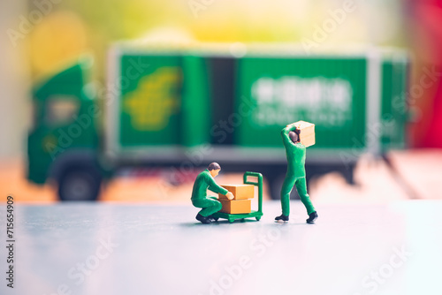 Miniature people, labourers carrying box using for logistic and business concept