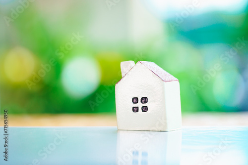 Closeup miniature house on green nature background using as property and family concept - Vintage filter