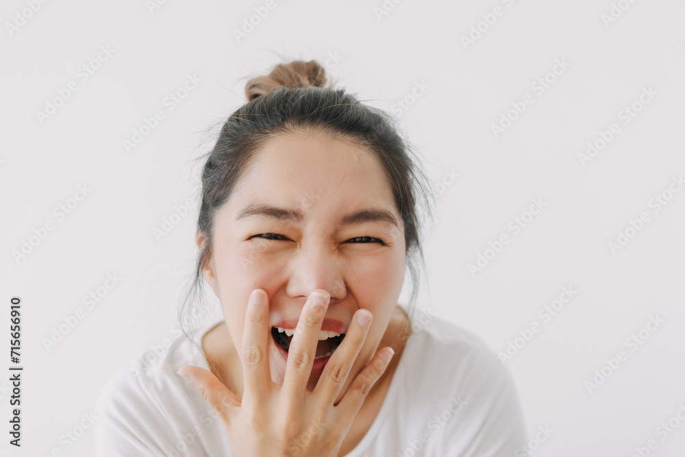 Happy asian Thai woman hand covering mouth while laughing, feeling glad and joyful, wear white and bun hairstyle, standing isolated over white background wall. Happy asian Thai woman hand covering mouth while laughing, feeling glad and joyful, wear white and bun hairstyle, standing isolated over white background wall.
