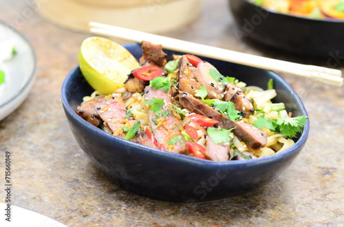 close up view of asian salad nam tok with noodles and beef