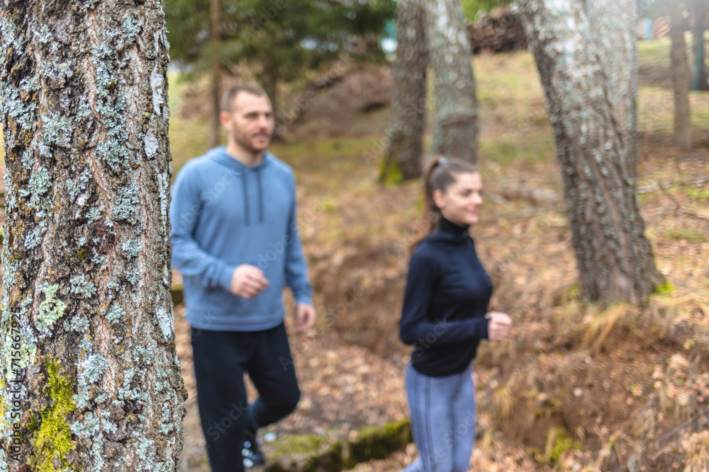 Happy Caucasian couple jogging in nature.