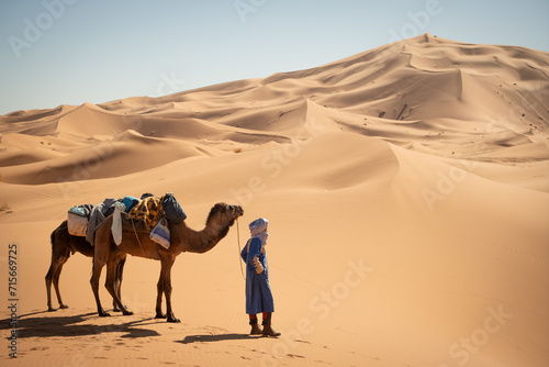 Man with a camel in the desert photo