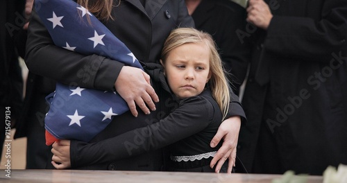 USA veteran funeral, girl and sad family with hug, care and flag for mourning, depression and comfort with mom. Kid, people and service with coffin, burial or memorial with war hero in Philadelphia