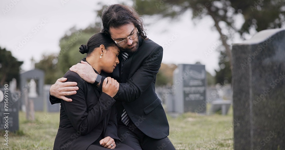 Sad couple, graveyard and hug in loss, grief or mourning together at funeral, tombstone or cemetery. Man holding woman in comfort, empathy or goodbye at memorial or burial service for death on grass Sad couple, graveyard and hug in loss, grief or mourning together at funeral, tombstone or cemetery. Man holding woman in comfort, empathy or goodbye at memorial or burial service for death on grass