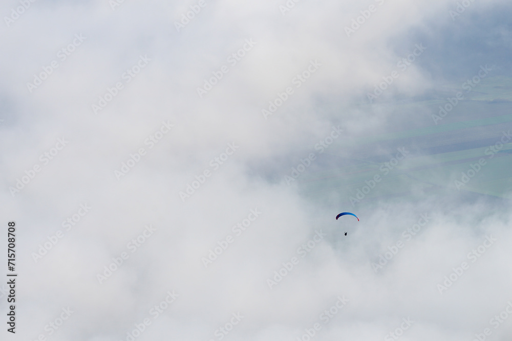 Two paragliders in the air on a cludy day at Hohe Wand in Lower Austria
