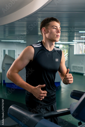 young athlete runs on a treadmill in the gym during cardio training process of losing weight
